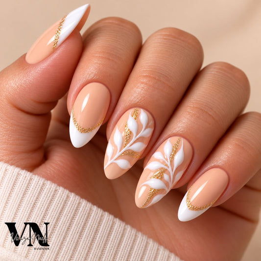press-on nails nude pêche et or avec motifs végétaux blancs, présenté dans une boîte Venuza Nails.