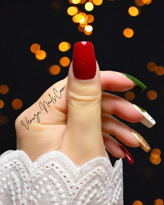 Ensemble de press-on nails aux couleurs de Noël : rouge brillant, vert sapin, doré pailleté et un ongle blanc décoré de petits sapins, pois rouges et dorés, avec un strass au centre.