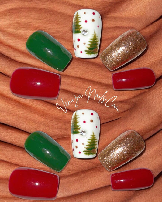 Ensemble de press-on nails aux couleurs de Noël : rouge brillant, vert sapin, doré pailleté et un ongle blanc décoré de petits sapins, pois rouges et dorés, avec un strass au centre.