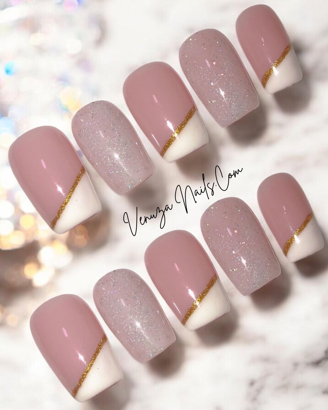 Faux ongles press-on Shanna de Venuza Nails – manucure rose nude avec french oblique blanche et fine ligne dorée, finition brillante et touches de paillettes.