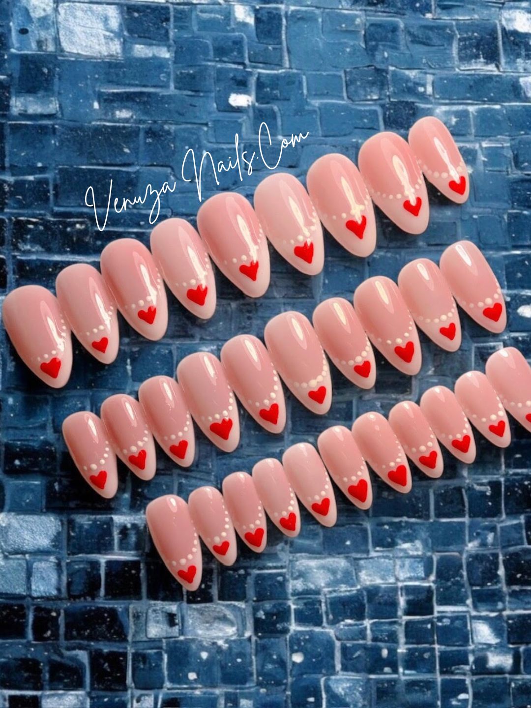 Faux ongles press-on rose nude à french blanche, nail art cœurs rouges et perles blanches, modèle romantique Venuza Nails.