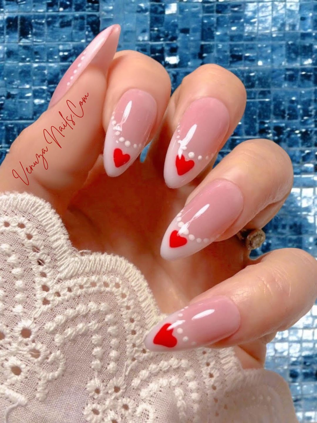 Faux ongles press-on rose nude à french blanche, nail art cœurs rouges et perles blanches, modèle romantique Venuza Nails.