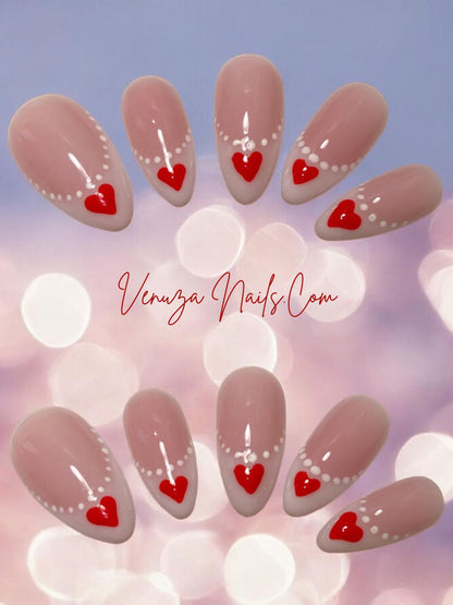 Faux ongles press-on rose nude à french blanche, nail art cœurs rouges et perles blanches, modèle romantique Venuza Nails.
