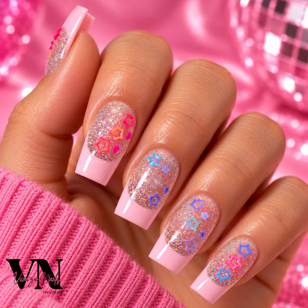 Manucure press-on en forme carrée avec French rose pâle, paillettes holographiques et charms étoiles colorés sur une main.