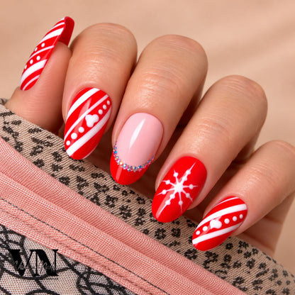 Manucure de Noël Santa en rouge et rose nude, décorée de rayures blanches, pois, cœurs et strass scintillants.