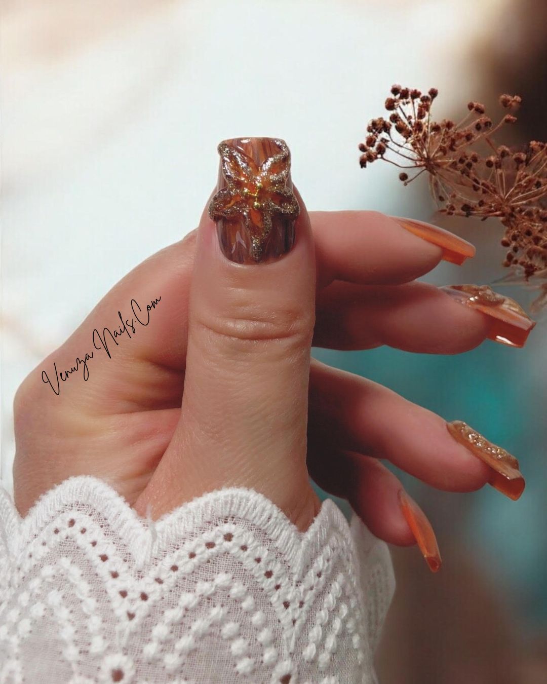 Manucure élégante avec les press-on nails “Amber Flora”, aux nuances boisées et fleurs dorées en 3D, mini perles dorées, parfaits pour l’automne.