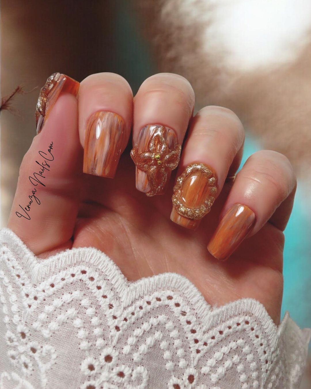 Manucure élégante avec les press-on nails “Amber Flora”, aux nuances boisées et fleurs dorées en 3D, mini perles dorées, parfaits pour l’automne.