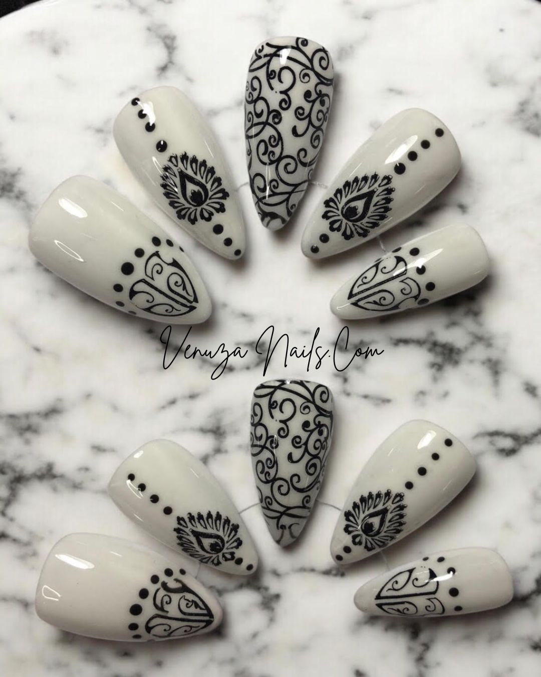  set de press on nails blancs aux motifs noirs de style baroque, avec arabesques , petits points délicats et volutes, peints à la main par Venuza Nails