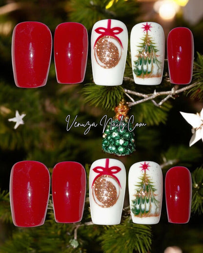 press-on nails rouges et blancs au style Noël. Deux ongles sont rouges brillants, un ongle blanc avec une boule dorée dessinée avec un ruban rouge, et un autre ongle blanc décoré d’un petit sapin de Noël doré et vert. Les capsules sont longues et brillantes, avec une ambiance festive et élégante.