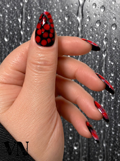 Jeune femme portant les press-on nails Maléfique rouge et noir, forme amande, Venuza Nails