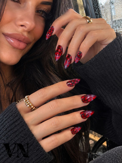 Jeune femme portant les press-on nails Maléfique rouge et noir, forme stiletto, Venuza Nails