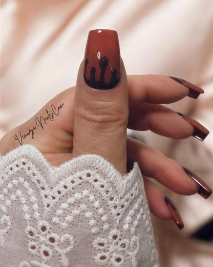 Press-on nails marron chocolat au design gouttes fondantes portés sur main de femme, pour un rendu élégant, sophistiqué et ultra gourmand, idéal pour la saison automnale.