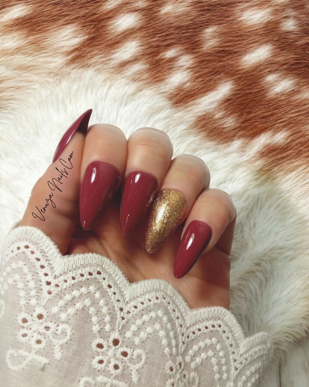 main féminine portant un kit de press on nails de couleur marron glacé, l'annulaire porte une teinte doré scintillante, signé Venuza Nails, tout est peint à la main .
