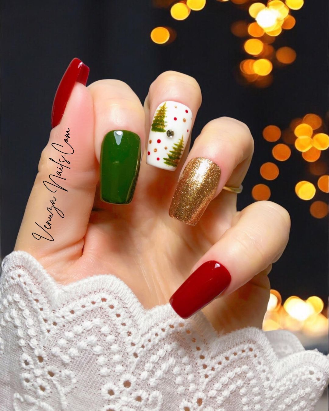 Ensemble de press-on nails aux couleurs de Noël : rouge brillant, vert sapin, doré pailleté et un ongle blanc décoré de petits sapins, pois rouges et dorés, avec un strass au centre. 