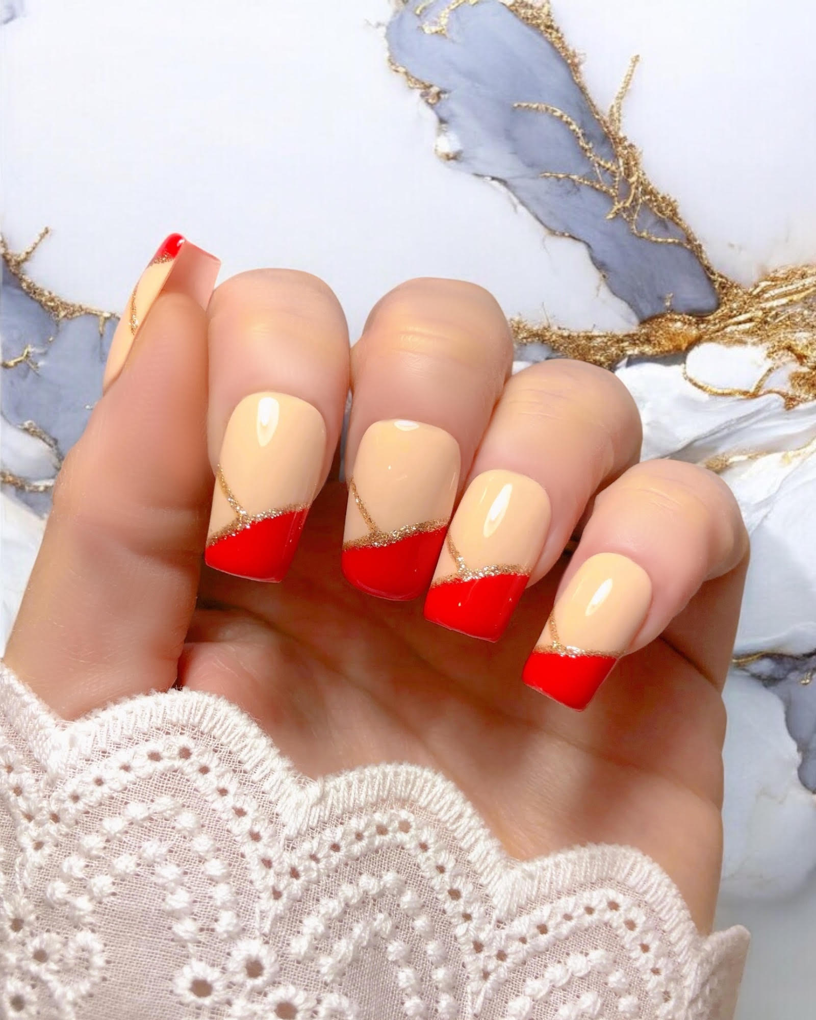 Faux ongles press-on Ruby — design chic avec base nude, French rouge rubis et fine ligne dorée, finition brillante, par Venuza Nails.