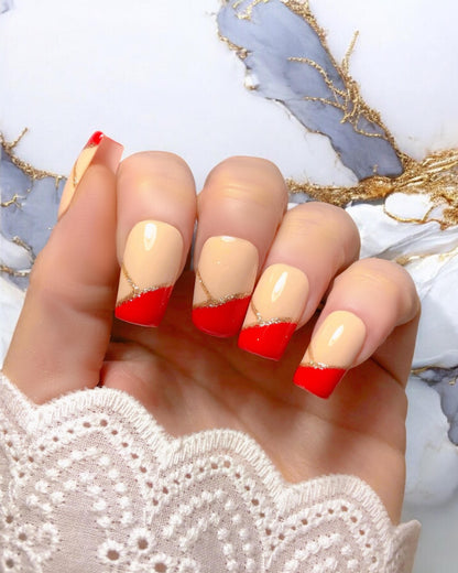 Faux ongles press-on Ruby — design chic avec base nude, French rouge rubis et fine ligne dorée, finition brillante, par Venuza Nails.