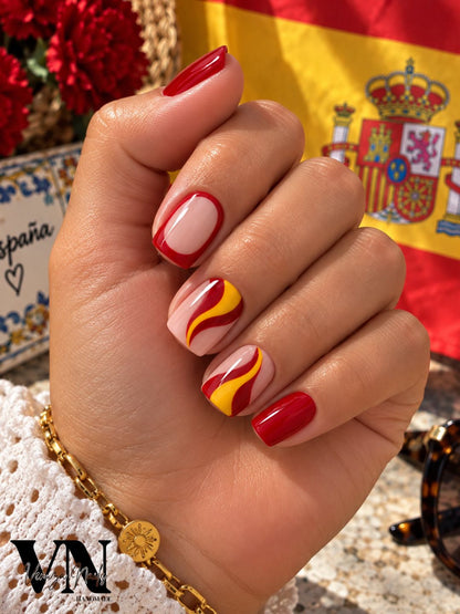 Faux ongles Espana rouge et jaune portés sur des ongles courts carrés