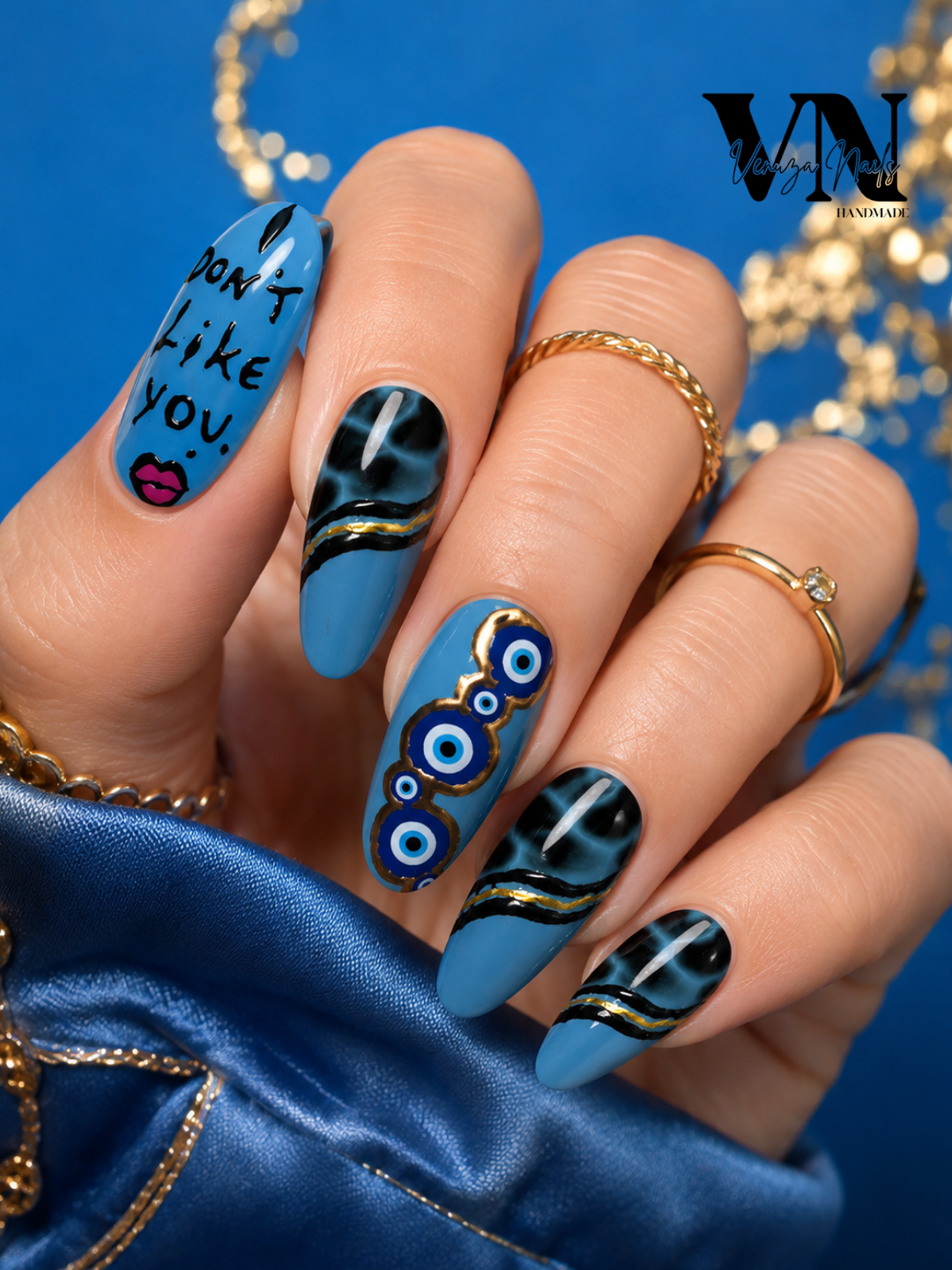 Press-On Nails Nazar Noir portés sur ongles amande long, nail art bleu, noir et or avec motifs œil turc et inscription « I DON'T LIKE YOU »