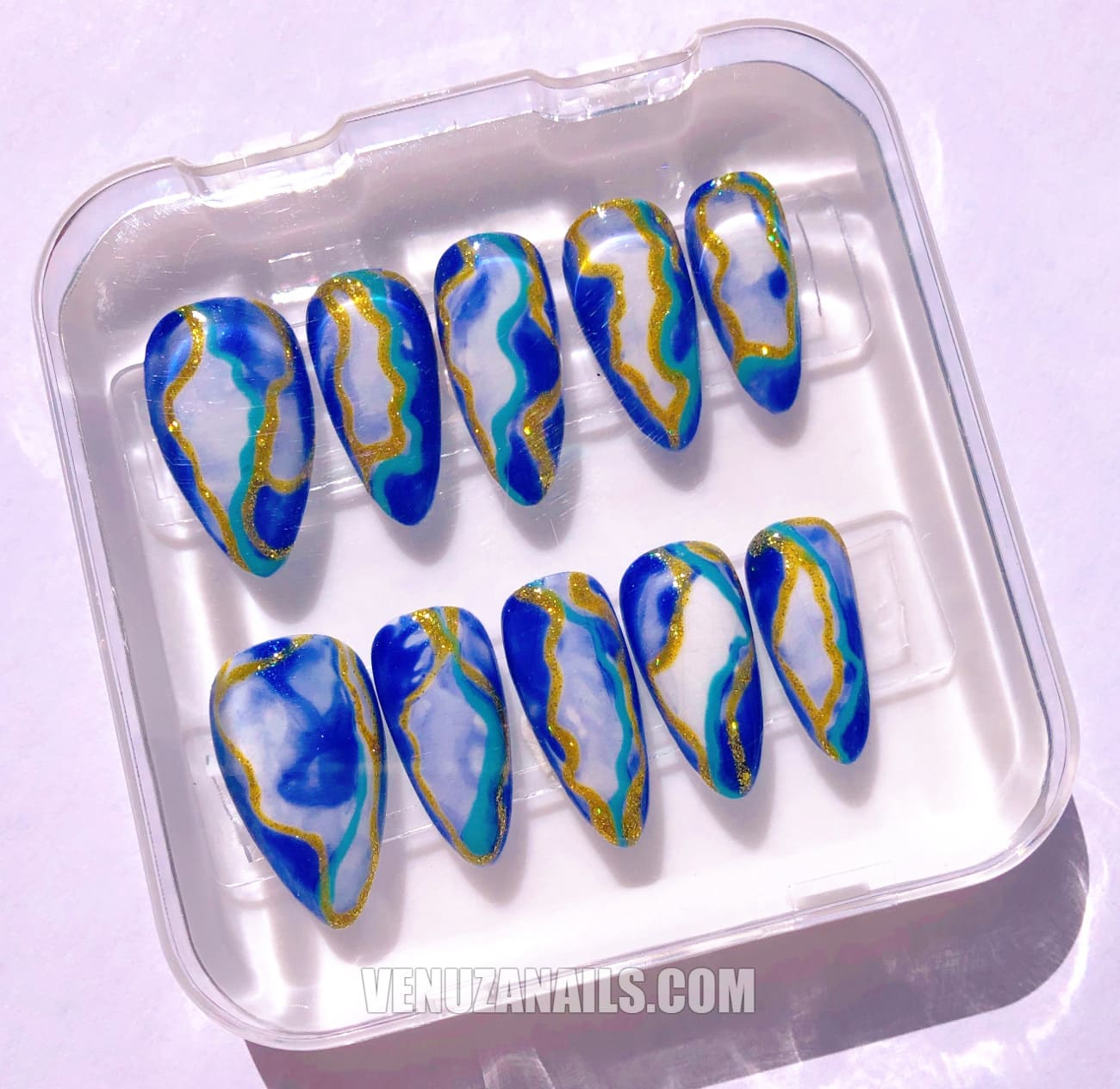 (zoom sur les motifs marbrés) :
alt="Faux ongles effet marbre bleu et doré – manucure élégante avec press-on nails Venuza Nails"
