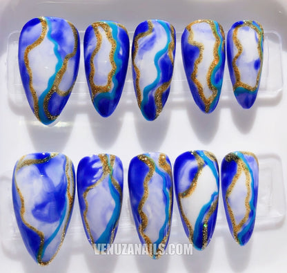 (zoom sur les motifs marbrés) :
alt="Faux ongles effet marbre bleu et doré – manucure élégante avec press-on nails Venuza Nails"