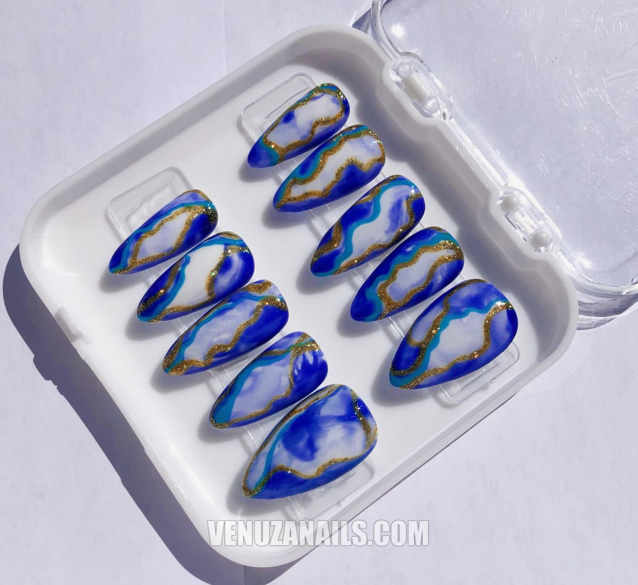 (zoom sur les motifs marbrés) :
alt="Faux ongles effet marbre bleu et doré – manucure élégante avec press-on nails Venuza Nails"