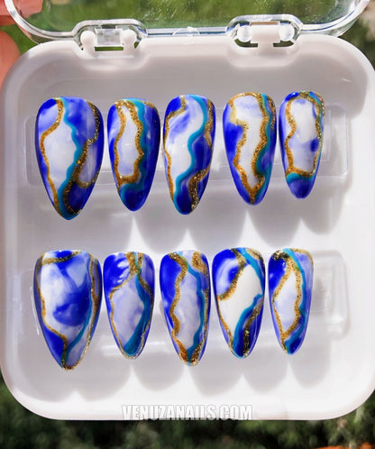 (zoom sur les motifs marbrés) :
alt="Faux ongles effet marbre bleu et doré – manucure élégante avec press-on nails Venuza Nails"