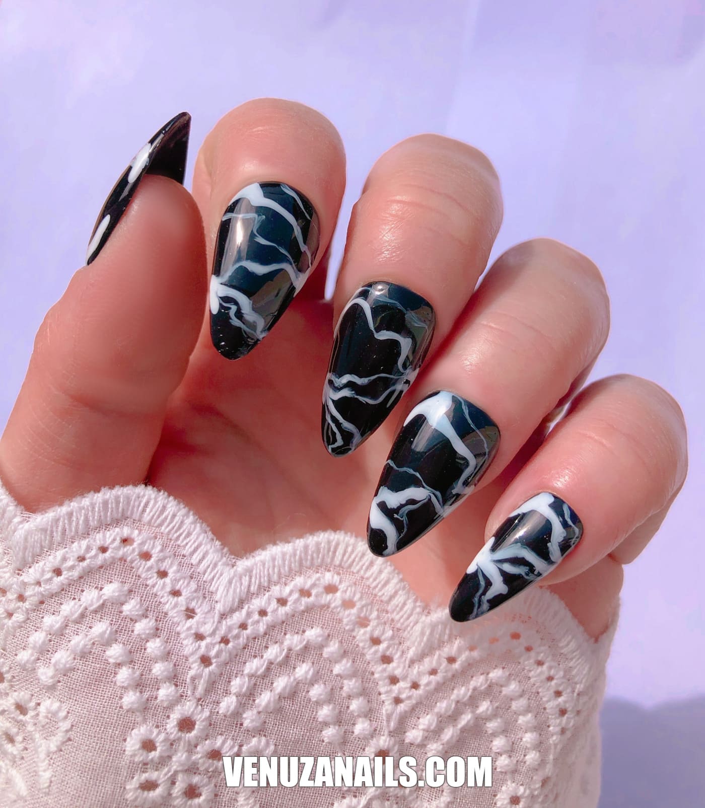 main montrant faux ongles marbrés noir et blanc