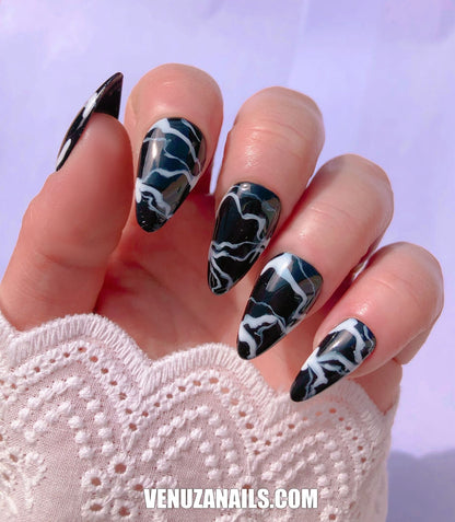 main montrant faux ongles marbrés noir et blanc