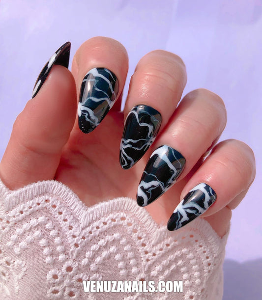 main montrant faux ongles marbrés noir et blanc