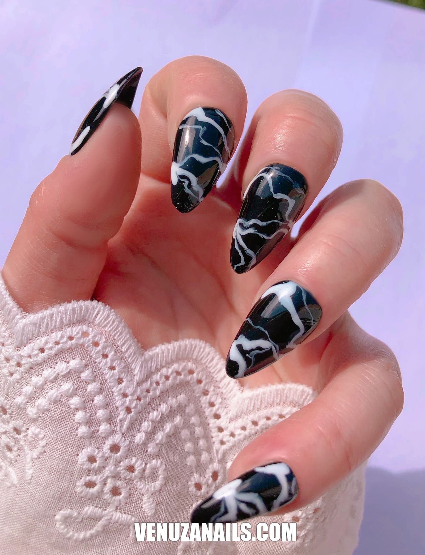 main montrant faux ongles marbrés noir et blanc
