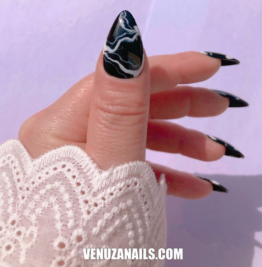 main montrant faux ongles marbrés noir et blanc