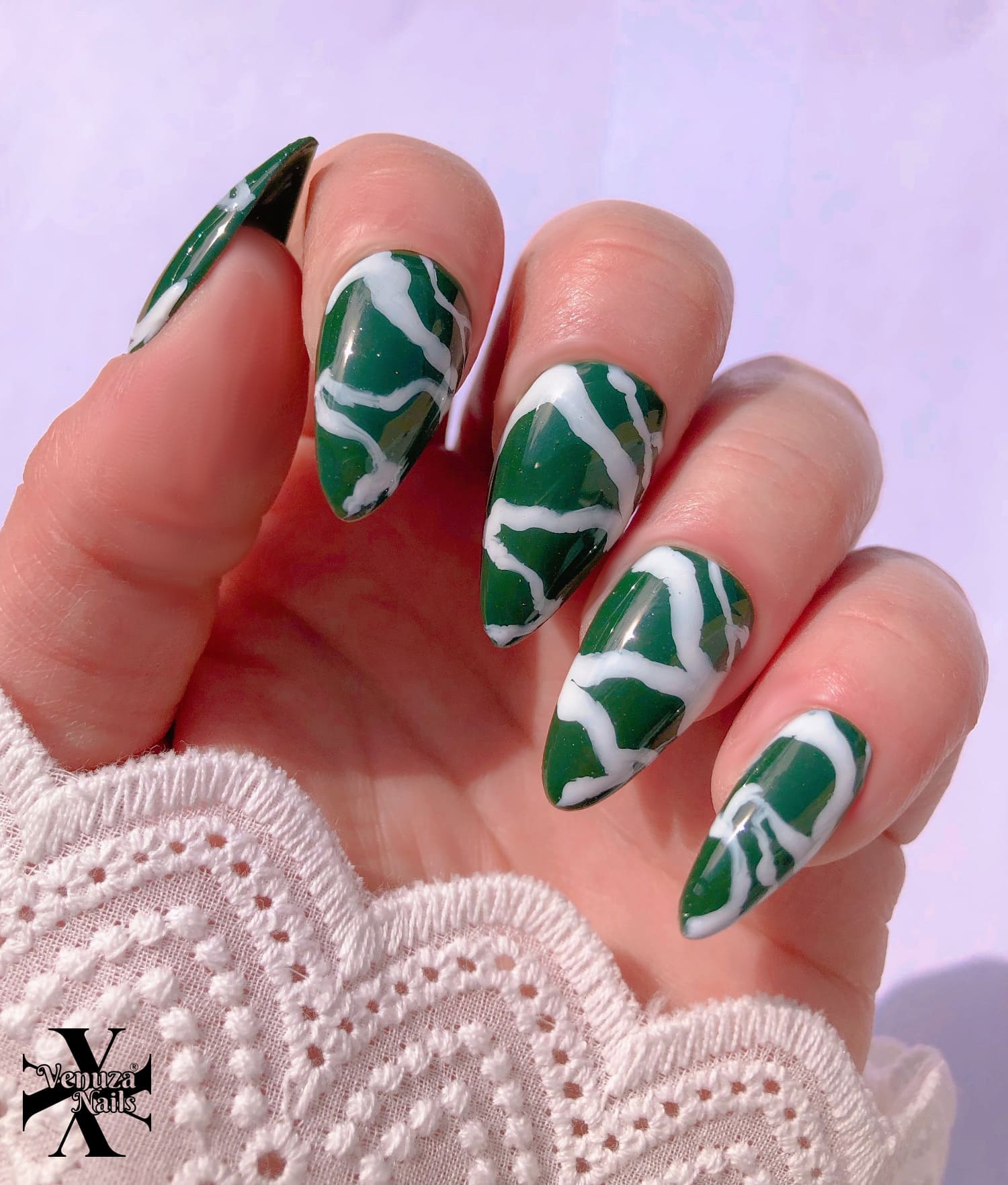 main montrant les ongles marbrés vert et blancs