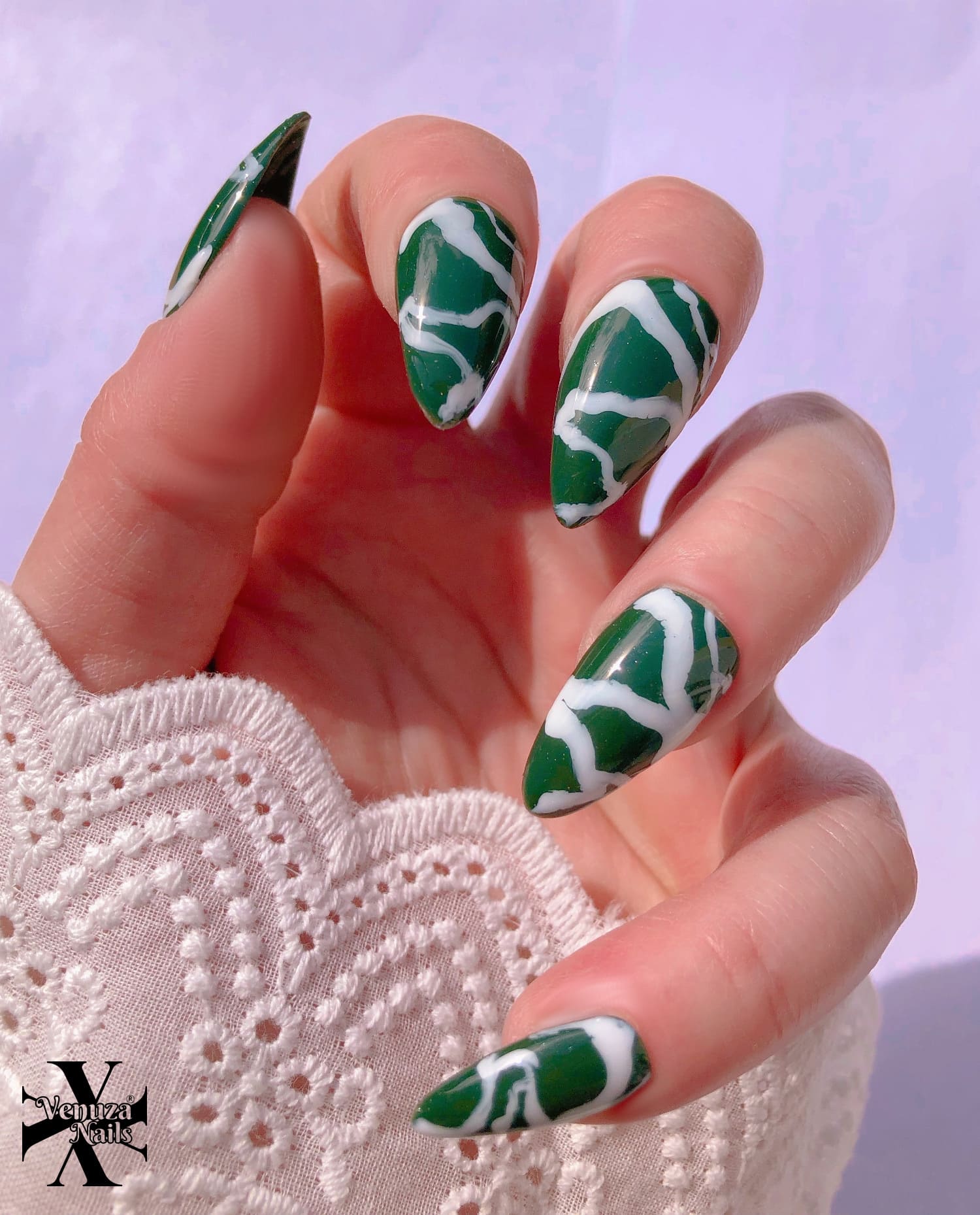 main montrant les ongles marbrés vert et blancs